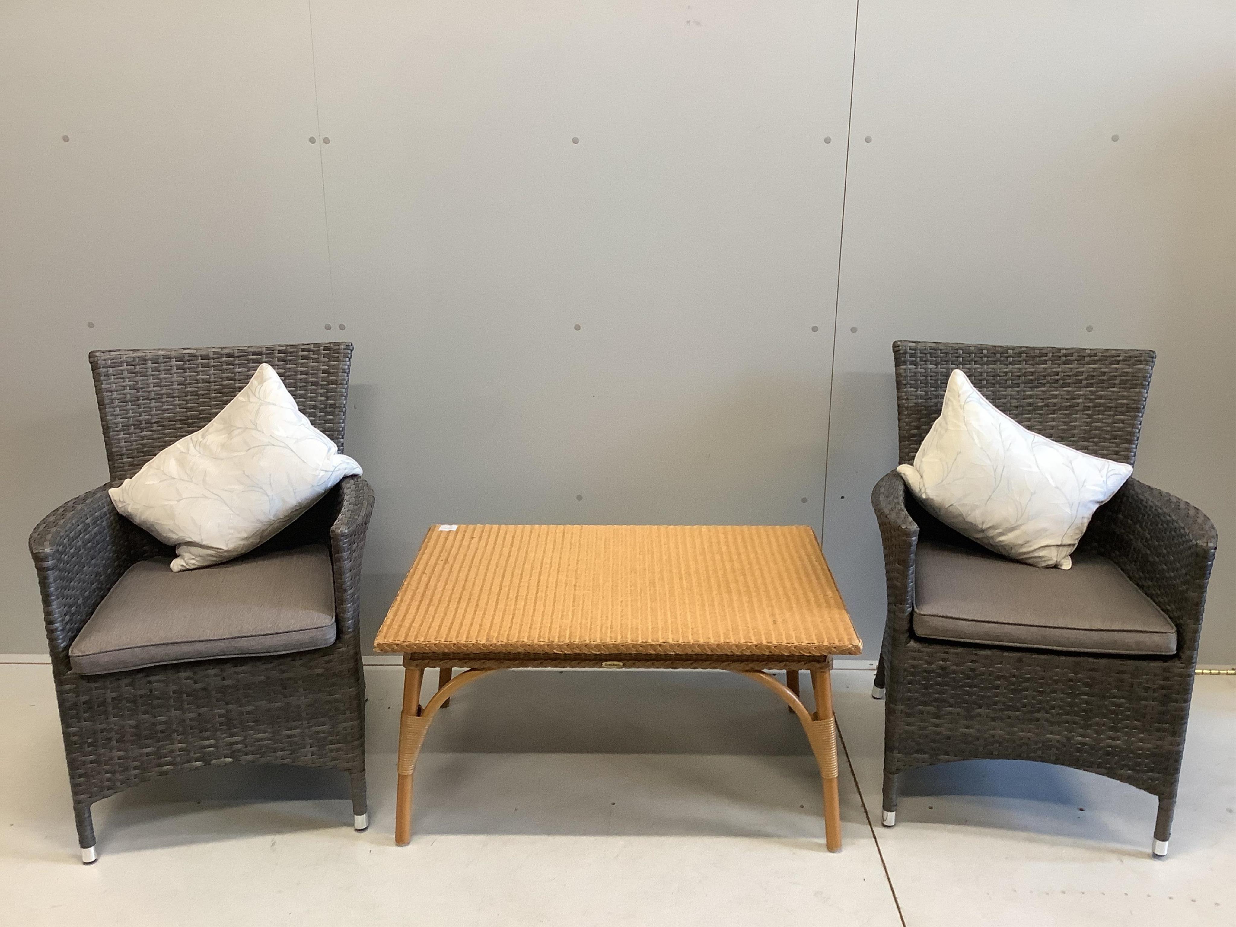 A pair of all weather rattan garden chairs with cushions, width 63cm, depth 56cm, height 90cm together with a rectangular rattan conservatory table. Condition - good